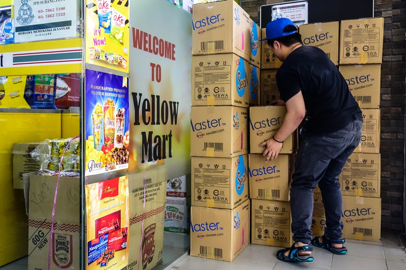 A worker arranges boxes of mineral water bottles for sale at a mart in Subang Jaya March 8, 2019. 