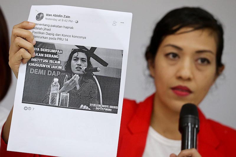 DAP Wanita assistant publicity secretary Syerleena Abdul Rashid holds a printout of a Facebook account that allegedly posts fake news during a press conference in George Town March 9, 2018. u00e2u20acu201d Picture by Sayuti Zainudin