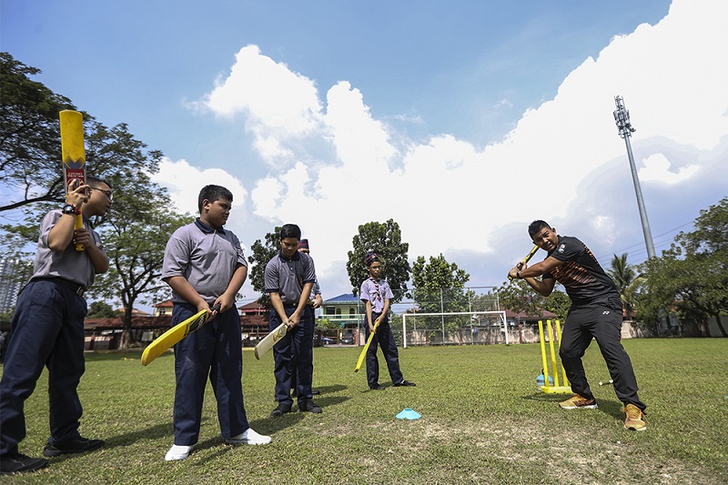 Negri Sembilan cricket captain Mohd Shafiq Shariff shows the children how itu00e2u20acu2122s done. u00e2u20acu201d Pictures by Azneal Ishak