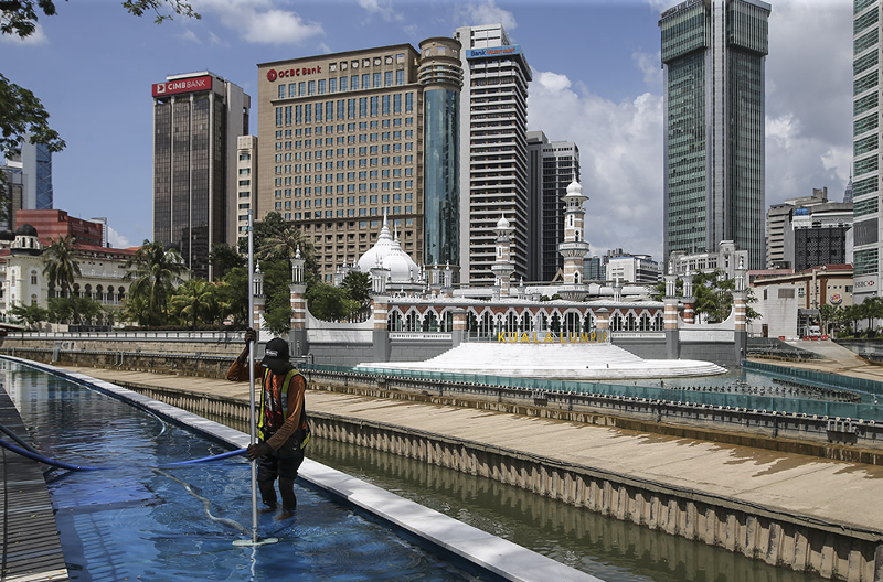 A worker cleans the River of Life and Blue Pond project at Jamek Mosque in Kuala Lumpur March 11, 2018. u00e2u20acu201d Picture by Azneal Ishak