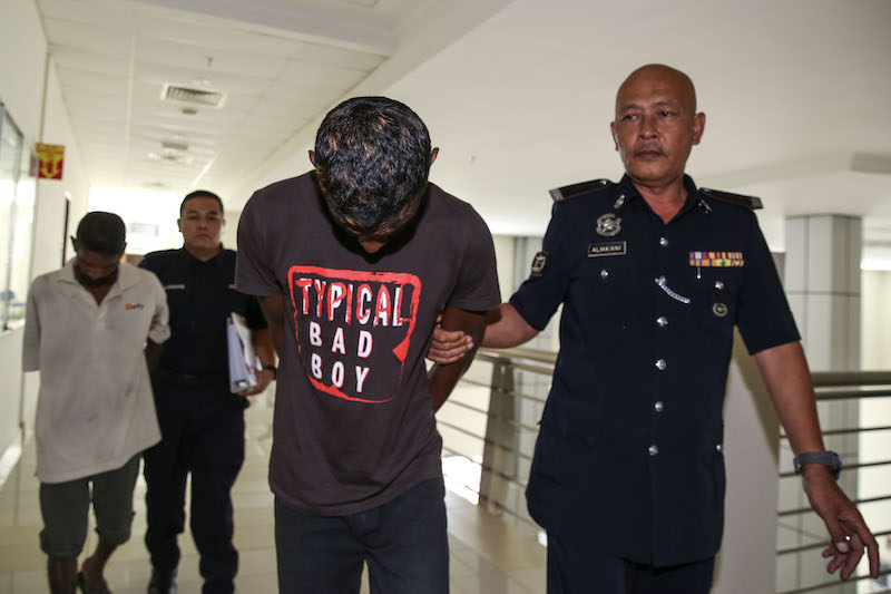 Suspects V. Chandramogan Verappan (front) and Somoo Nagapain (behind) are escorted by police at the Sessions Court in Klang March 23, 2018. u00e2u20acu201d Picture by Yusof Mat Isa