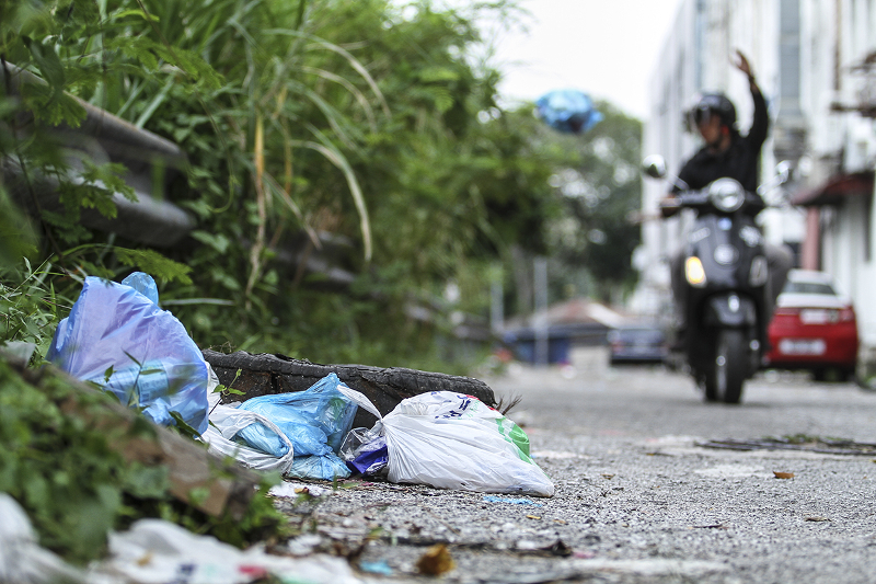 A man is seen throwing garbage near shop lots in Petaling Jaya. u00e2u20acu201d Picture by Shafwan Zaidon