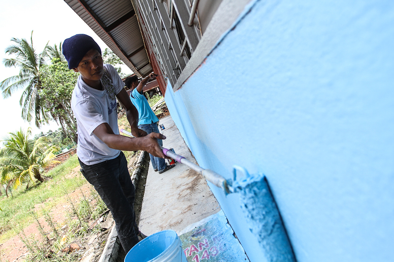 A Redberry staff painting the walls of Sekolah Agama Felda in Gemas as part of their CSR programme, March 31, 2018. u00e2u20acu201d Picture by Shafwan Zaidon