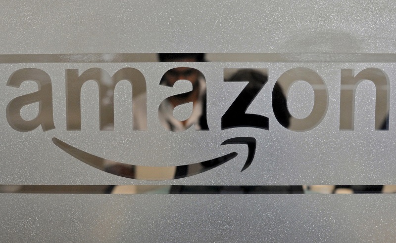 Employees of Amazon India are seen behind a glass bearing the company's logo inside its office in Bengaluru, India August 14, 2015. u00e2u20acu201d Reuters pic