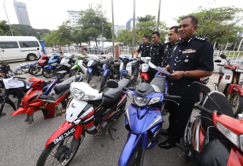 Shah Alam police chief Assistant Commissioner Baharuddin Mat Taib (right) stands among seized motorcycles during a press conference this afternoon March 1, 2018. u00e2u20acu2022 Picture by Zuraneeza Zulkifli 