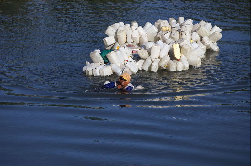 This photo taken on March 22, 2018 shows Indonesian Hasria swimming with hundreds of jars tied to her back to get clean water in Tinambung, West Sulawesi. u00e2u20acu201d AFP pic