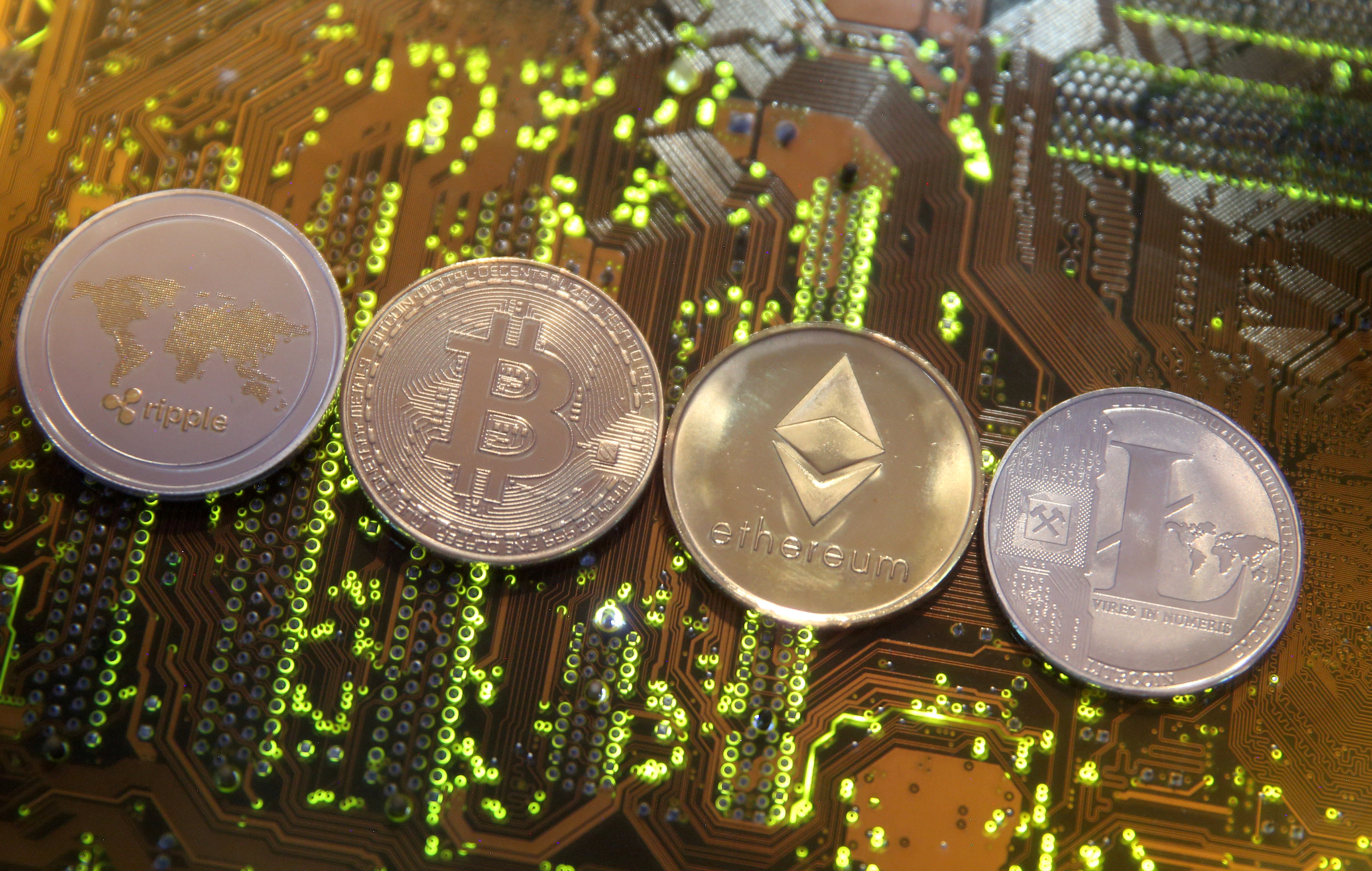 Representations of the Ripple, Bitcoin, Etherum and Litecoin virtual currencies are seen on a PC motherboard in this illustration picture, February 13, 2018. u00e2u20acu201d Reuters pic 