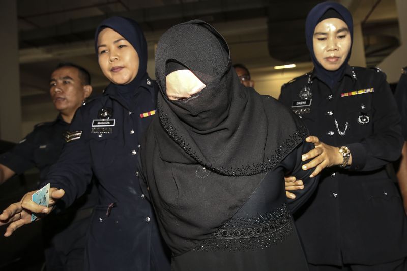 Rozita Mohamad Ali (centre) is escorted by police at the Shah Alam High Court on March 29, 2018. u00e2u20acu2022 Picture by Yusof Mat Isa 