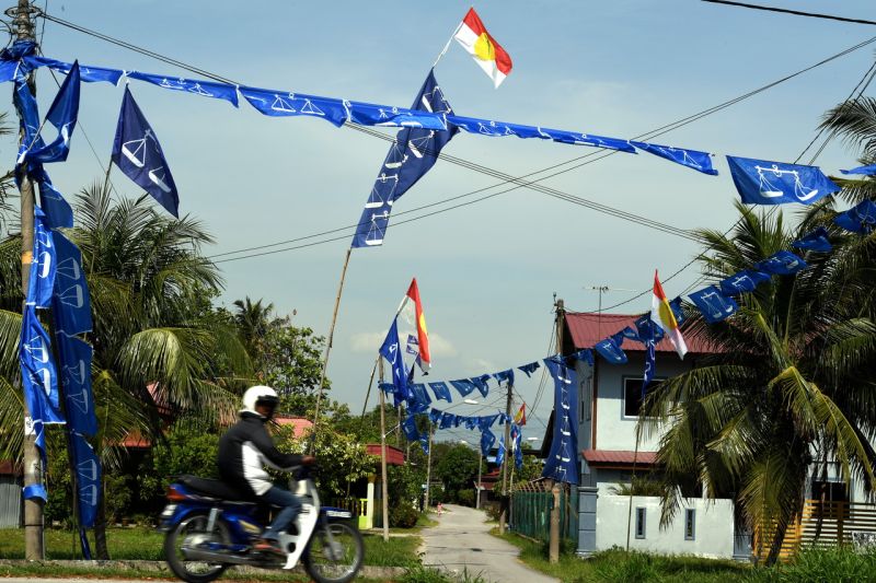 A motorcyclist rides past Barisan Nasional flags at Kampung Permatang Tengah in Bukit Mertajam March 29, 2018. u00e2u20acu2022 Bernama pic