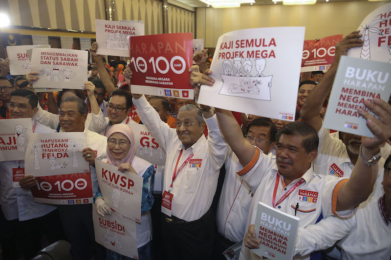 Pakatan Harapan leaders pose for photos while holding banners with manifesto pledges after the launch of Buku Harapan in Shah Alam March 8, 2018.