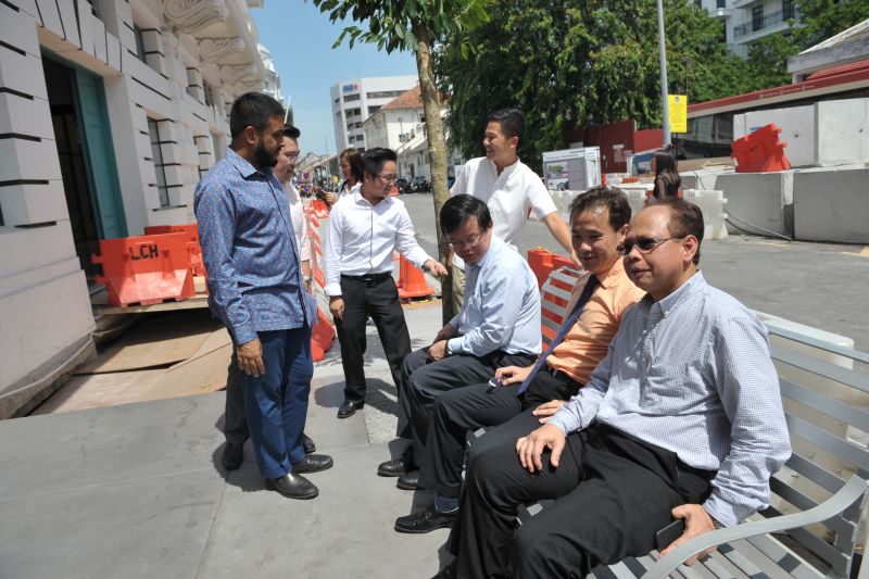 Penang Exco Chow Kon Yeow (seated, left) and MBPP Mayor Yew Tung Seang (seated, centre) sit on one of the public chairs at China Street Ghaut in George Town March 1, 2018.