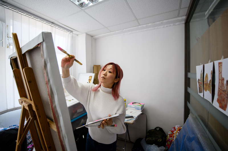 Mural artist Jackie Chung, 36, who works under the name 'Pinkhead,' paints during an interview. u00e2u20acu201d AFP pic