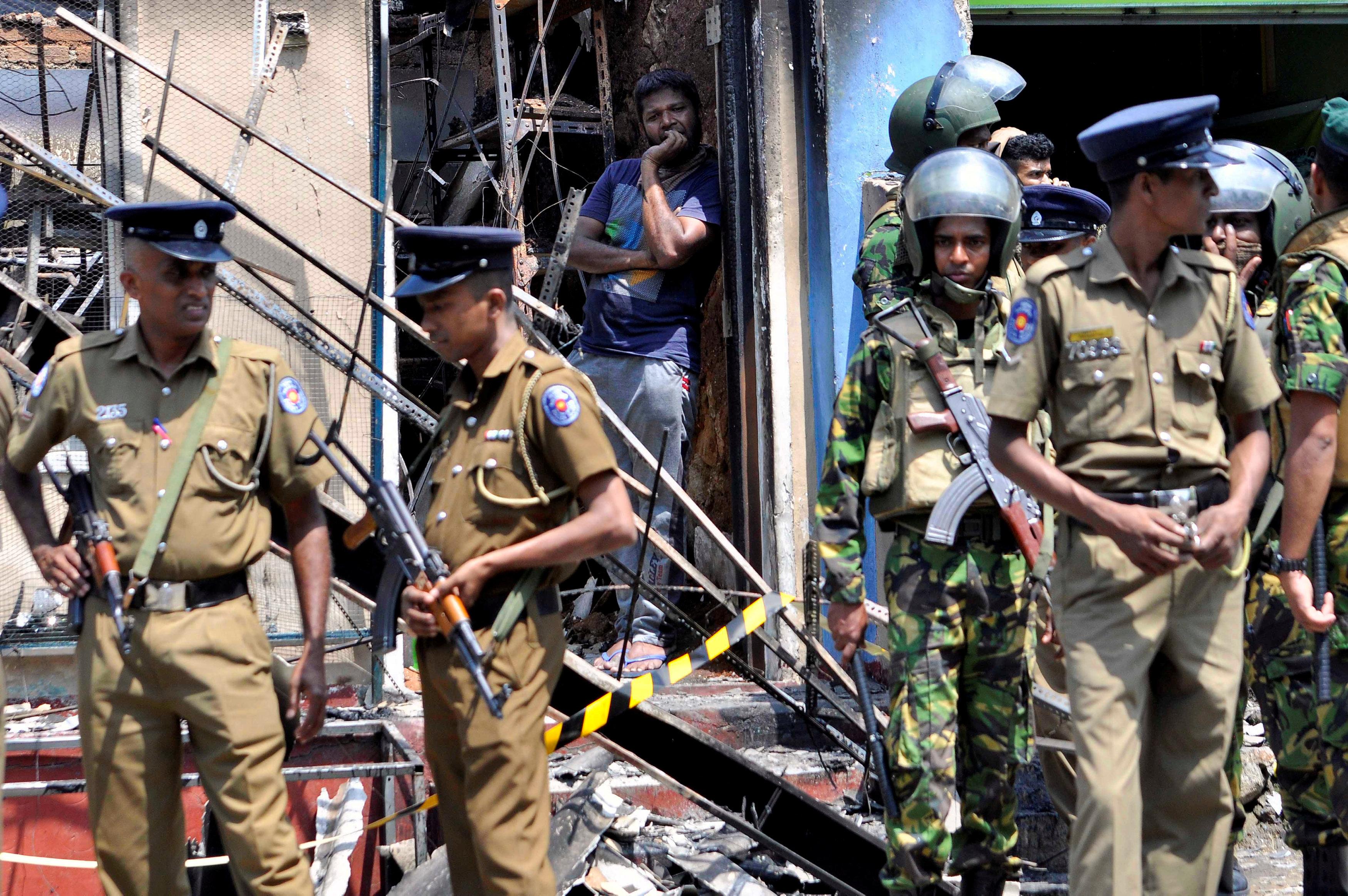 Sri Lanka's Special Task Force and Police officers stand guard near a burnt house after a clash between two communities in Digana, central district of Kandy, Sri Lanka March 6, 2018. u00e2u20acu201d Reuters pic