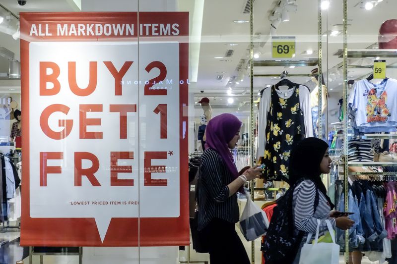 Shoppers walk past a sale sign on display in front of a retail outlet in the Mid Valley Megamall, Kuala Lumpur March 14, 2018. u00e2u20acu201d Picture by Shafwan Zaidon