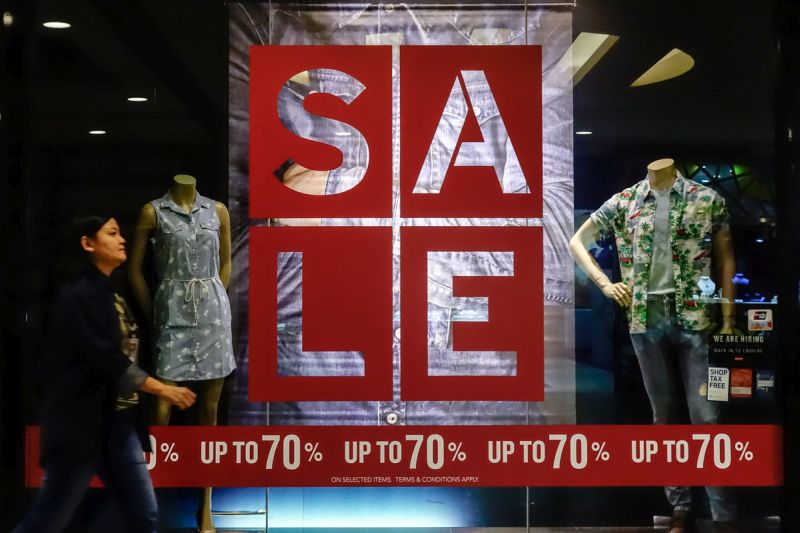 Shoppers walk past a sale sign on display in front of a retail outlet in the Mid Valley Megamall, Kuala Lumpur March 14, 2018. u00e2u20acu201d Picture by Shafwan Zaidon