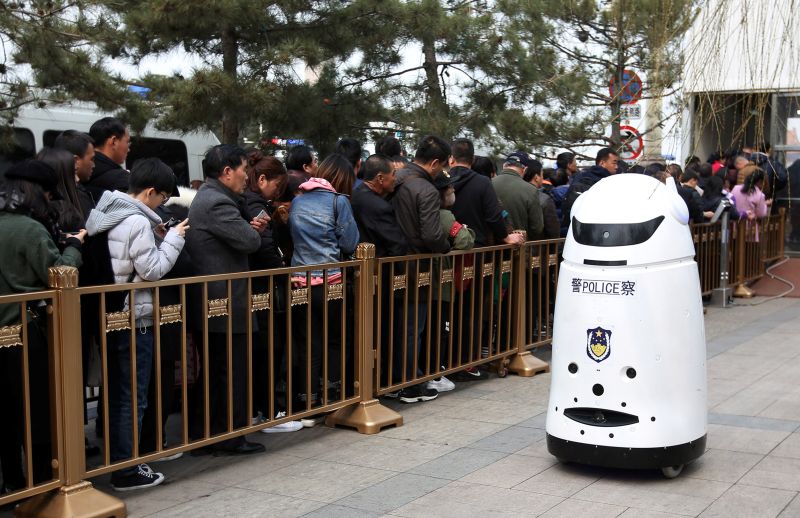 A police robot patrols as visitors queue for security check at an entrance to the Tiananmen Square in Beijing March 24, 2018. u00e2u20acu201d Reuters pic