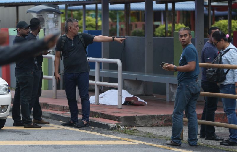 The body of a man, who was shot dead at the bus stop in front of SK Sri Serdang in Seri Kembangan, is covered with a piece of white cloth March 1, 2018. u00e2u20acu2022 Picture by Razak Ghazali