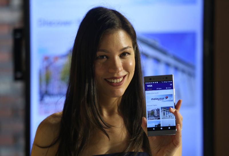Nadia Heng Min Dern shows a mobile app during the launch of the travel mobile app Pick-A-Trip in Kuala Lumpur March 13, 2018,.u00e2u20acu2022 Picture by Razak Ghazali