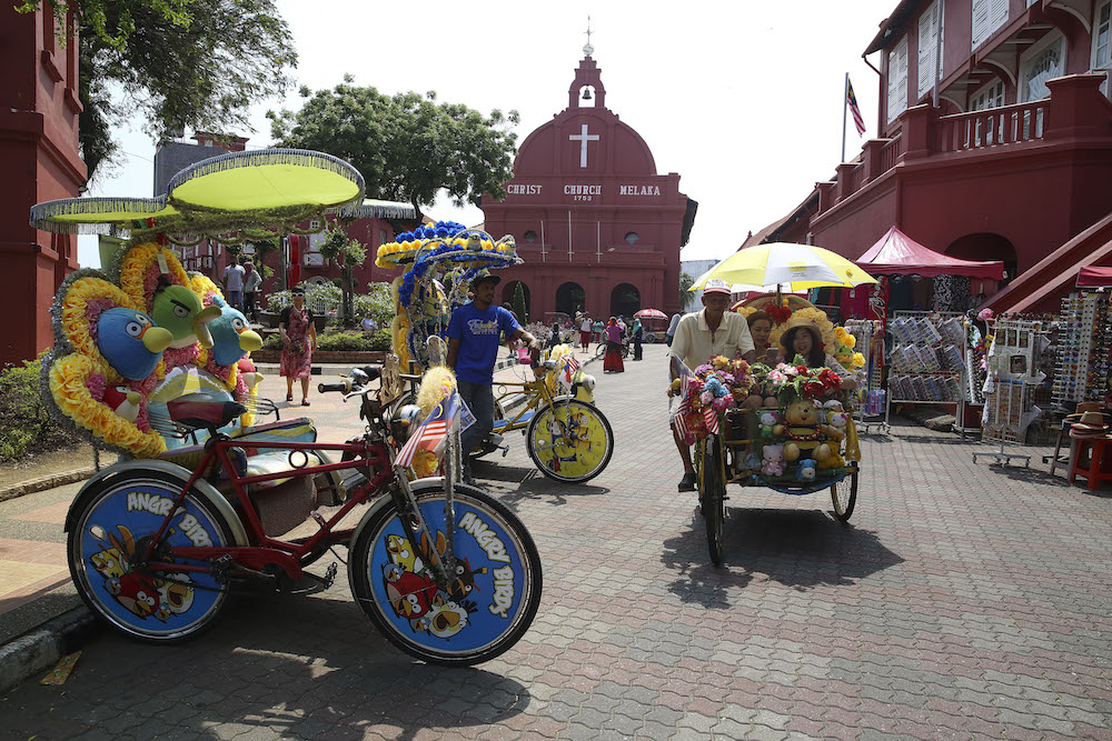 Tourists take a photo in front of the Stadthuys Building in Melaka April 1, 2018. u00e2u20acu201d Picture by Yusof Mat Isa