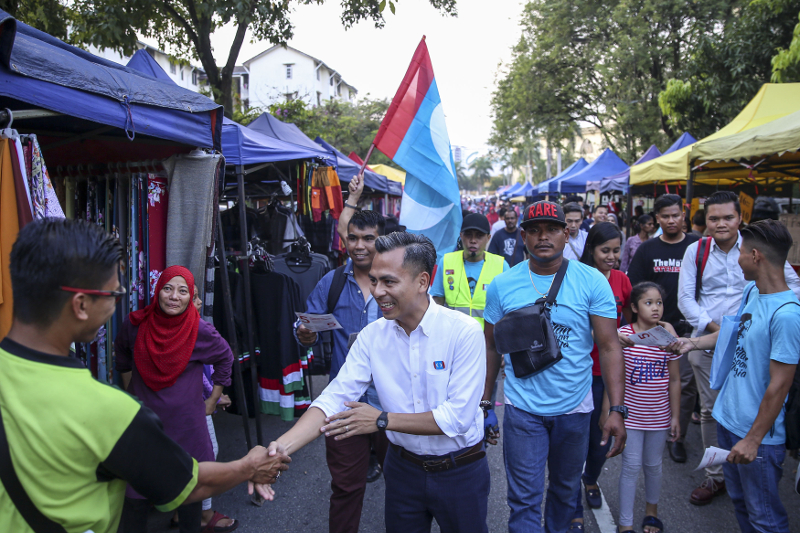 PKR’s Lembah Pantai candidate Fahmi Fadzil greets residents during a walkabout session at the Sri Sentosa night market in Kuala Lumpur April 12, 2018. — Picture by Yusof Mat Isa