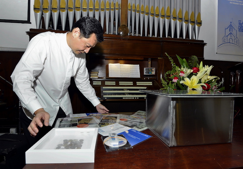 St Andrew’s Secretary Centenary Steering Committee member Kenneth Tan arranges all the items that will be placed in the second time capsule. — Picture by Ham Abu Bakar