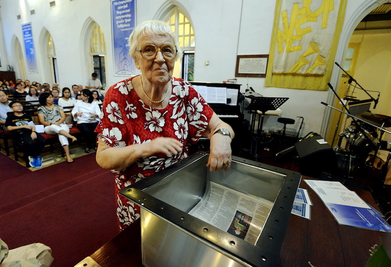 Parishioner of St Andrew’s Church, Joyce Keep, places Malay Mail articles in the second time capsule. — Picture by Ham Abu Bakar