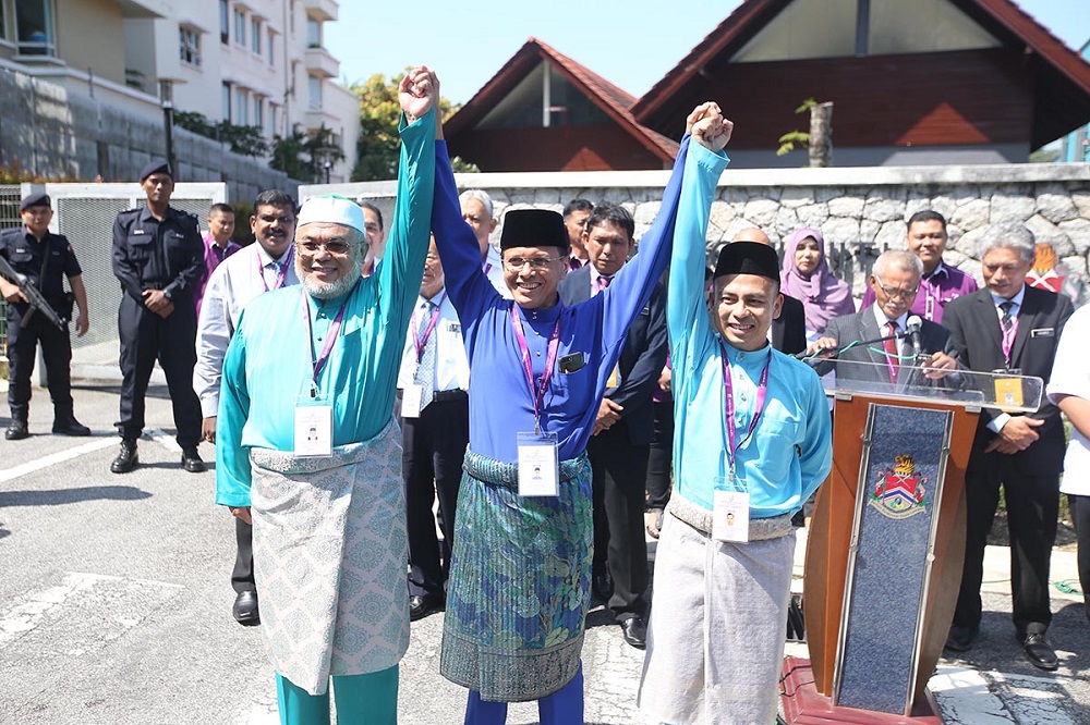 (From left) PASu00e2u20acu2122 Fauzi Abu Bakar, BN's Datuk Seri Raja Nong Chik Zainal Abidin and PKR's Fahmi Fadzil pose for a picture after the nomination process in Lembah Pantai April 28, 2018. u00e2u20acu201d Picture by Azinuddin Ghazali