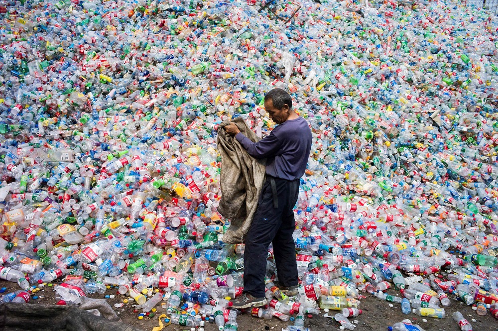 This file photo taken on September 17, 2015 shows a Chinese labourer sorting out plastic bottles for recycling in Dong Xiao Kou village, on the outskirt of Beijing. — AFP pic