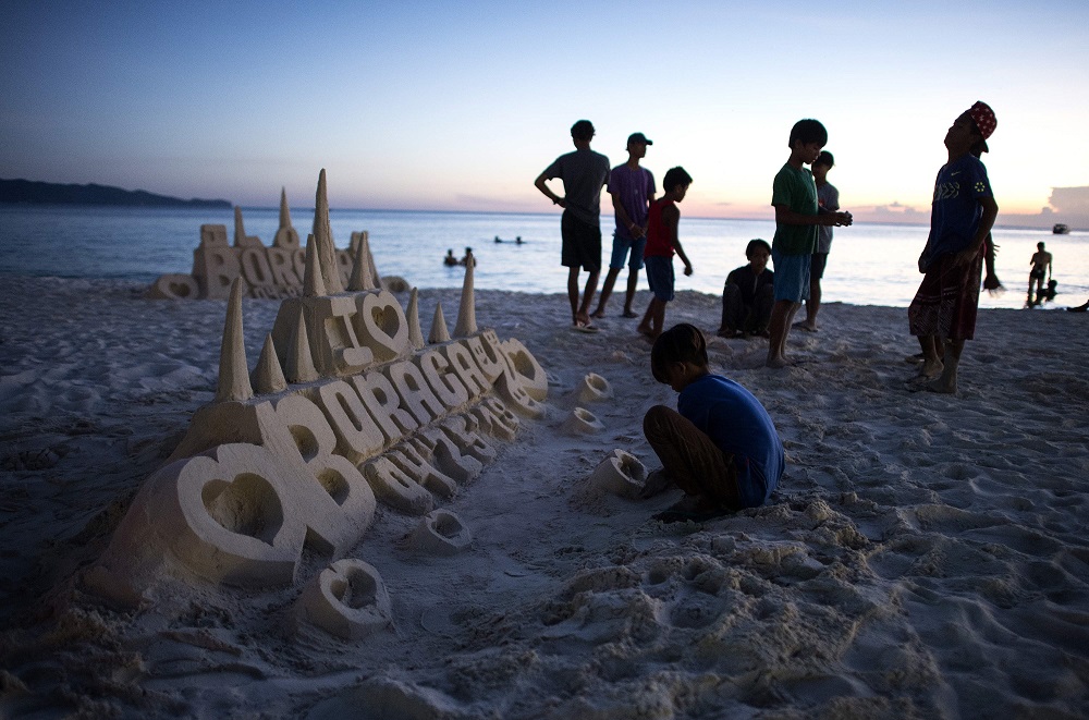 This photo taken on April 25, 2018 shows a boy making a sand castle on the Philippine island of Boracay. u00e2u20acu201d AFP pic