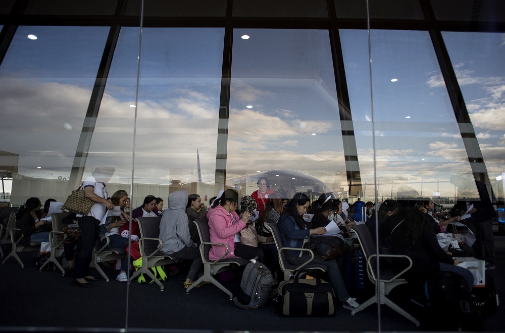 In this file photo taken on February 18, 2018, Filipina workers returning home from Kuwait fill out forms upon their arrival at Manila International Airport. u00e2u20acu201d AFP pic
