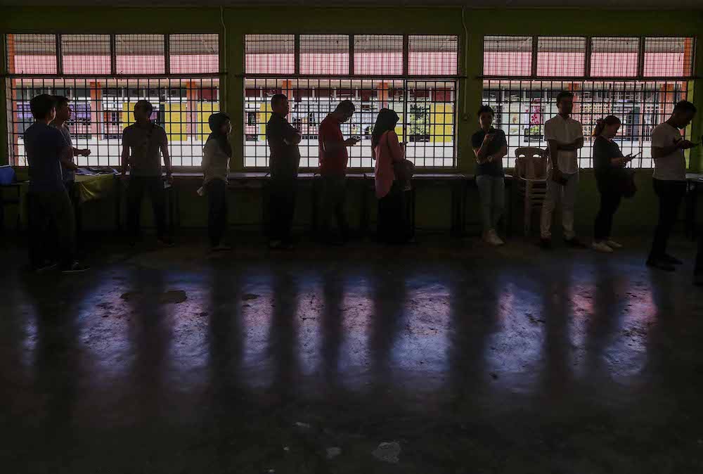 Voters queue up to cast their votes outside a polling station during the 14th general elections in SMK Sri Muar, Muar May 9, 2018. u00e2u20acu201d Picture by Firdaus Latif