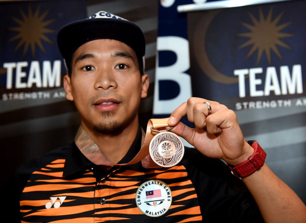 Two-time national champion Mohd Nafiizwan Adnan shows off the bronze medal he won at the Commonwealth Games in Gold Coast upon arrival at klia2, April 14, 2018. u00e2u20acu201d Bernama pic