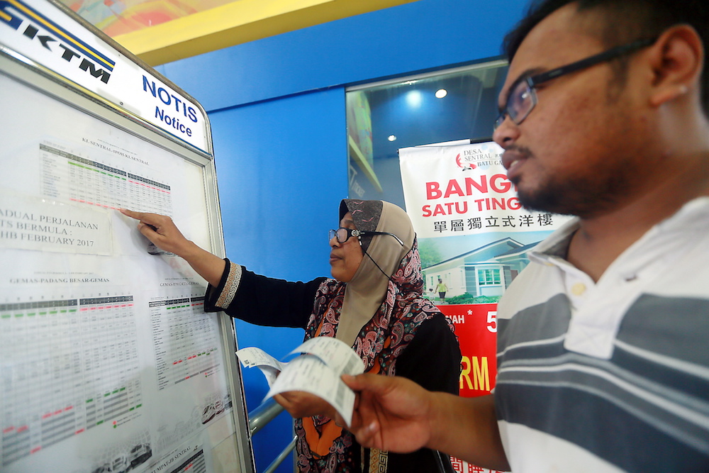 Aspalela Mohd Ismail and her son Muhd Badrul Idzam study the ETS timetable for the Hari Raya Aidilfitri holidays at the Ipoh Railway Station May 29, 2017. u00e2u20acu201d Picture by Farhan Najib