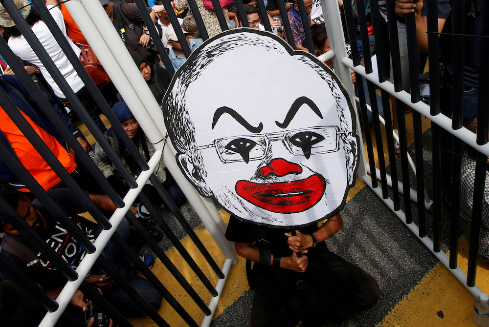 A student activist holds up a placard of Fahmi Rezau00e2u20acu2122s caricature of Datuk Seri Najib Razak during a protest to call for the arrest of u00e2u20acu02dcMalaysian Official 1u00e2u20acu2122 in Kuala Lumpur August 27, 2016. u00e2u20acu201d Reuters pic