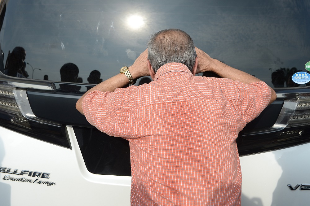 A man peers into a white Vellfire as the vehicle makes its way into the Sultan Abdul Aziz Shah Airport in Subang Jaya.