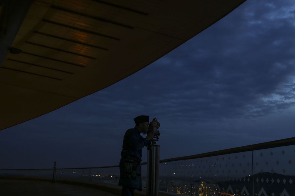 An Islamic religious department officer performing the u00e2u20acu02dcrukyahu00e2u20acu2122 the sighting of the new moon of Ramadan in Putrajaya on May 15, 2018. u00e2u20acu201d Picture by Yusof Mat Isa