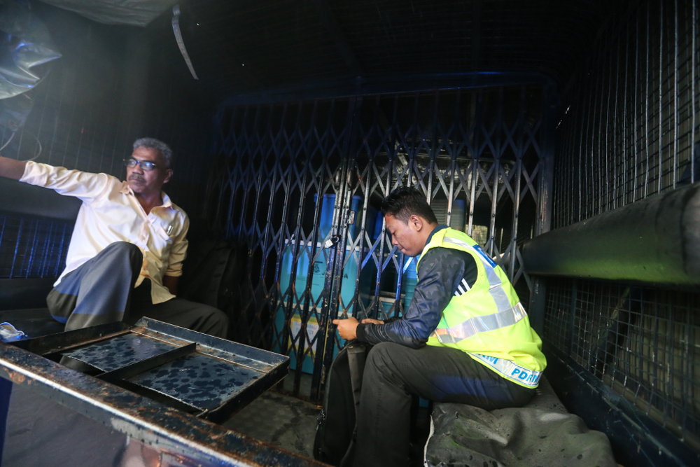 Police trucks are seen leaving Datuk Seri Najib Razak’s house carrying boxes believed to be personal belongings related to an ongoing money laundering probe May 17, 2018. — Picture by Ahmad Zamzahuri