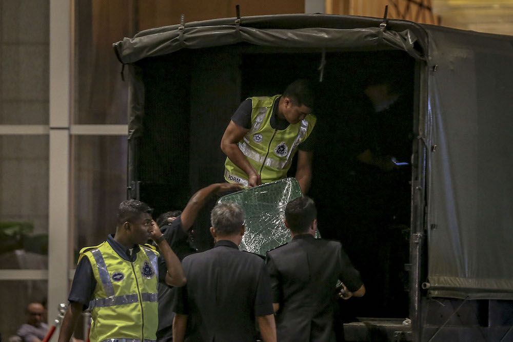 Investigators lift sealed luggage onto a Black Maria outside Pavilion Residences in Kuala Lumpur May 18, 2018. u00e2u20acu201d Picture by Hari Anggara  