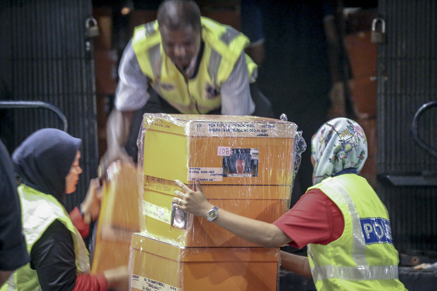 Investigators lift sealed boxes believed to contain luxury designer bags onto a Black Maria outside Pavilion Residences in Kuala Lumpur May 18, 2018. u00e2u20acu201d Picture by Hari Anggara  n
