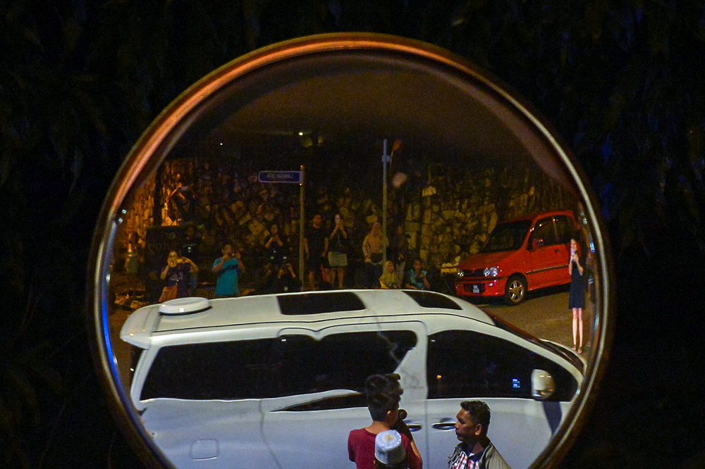 Datuk Seri Najib Razak’s car and members of the public are reflected on a street mirror as the former prime minister arrives home from tarawih prayer in Taman Duta, May 19, 2018. — Picture by Mukhriz Hazim