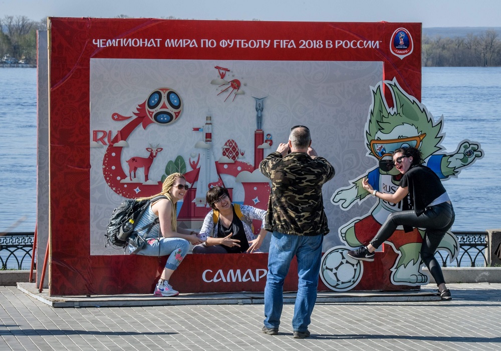 People take pictures with the logo and the insignia of the 2018 Fifa World Cup on an embankment of the Volga river in Samara on May 5, 2018. u00e2u20acu201d AFP pic