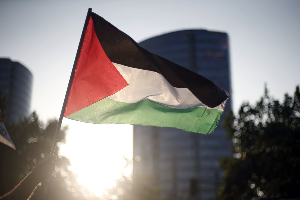 A protester waves a Palestinian flag during a demonstration against US President Donald Trump's recognition of Jerusalem as the capital of Israel, in front of the United States embassy in Santiago December 11, 2017. u00e2u20acu201d AFP pic