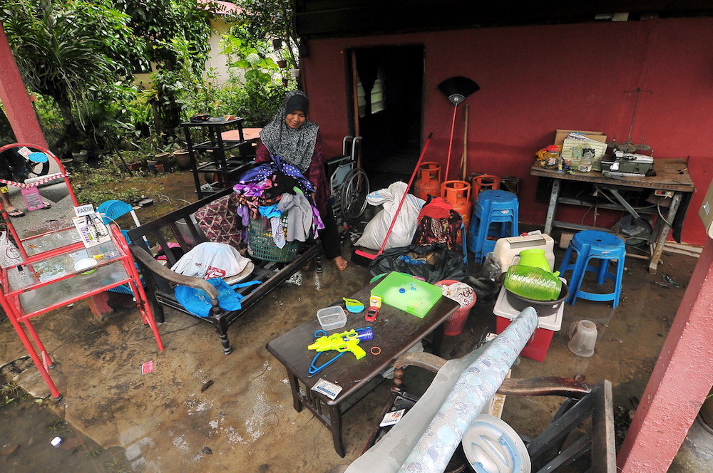 Maizatun Akmam Yahya cleans up in the aftermath of flooding in Kamping Tepi Sungai in Tasek Gelugor, Penang May 29, 2018. u00e2u20acu201d Bernama pic