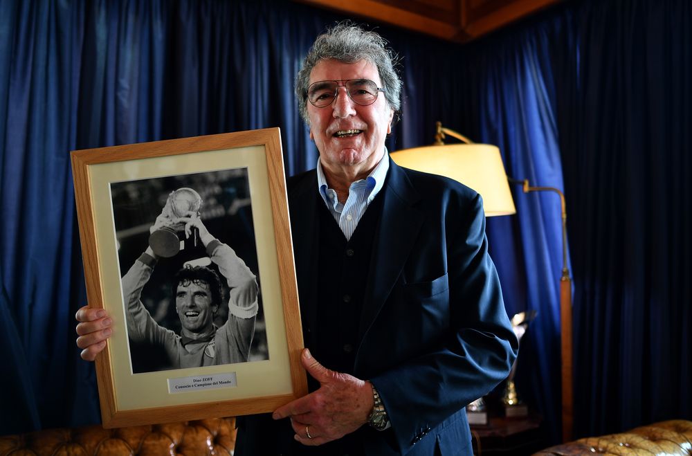 Former Italian goalkeeper and coach Dino Zoff poses with a picture of him holding the trophy of the Fifa football World Cup in 1982, during an interview with AFP in Rome, on April 13, 2018. u00e2u20acu201d AFP pic