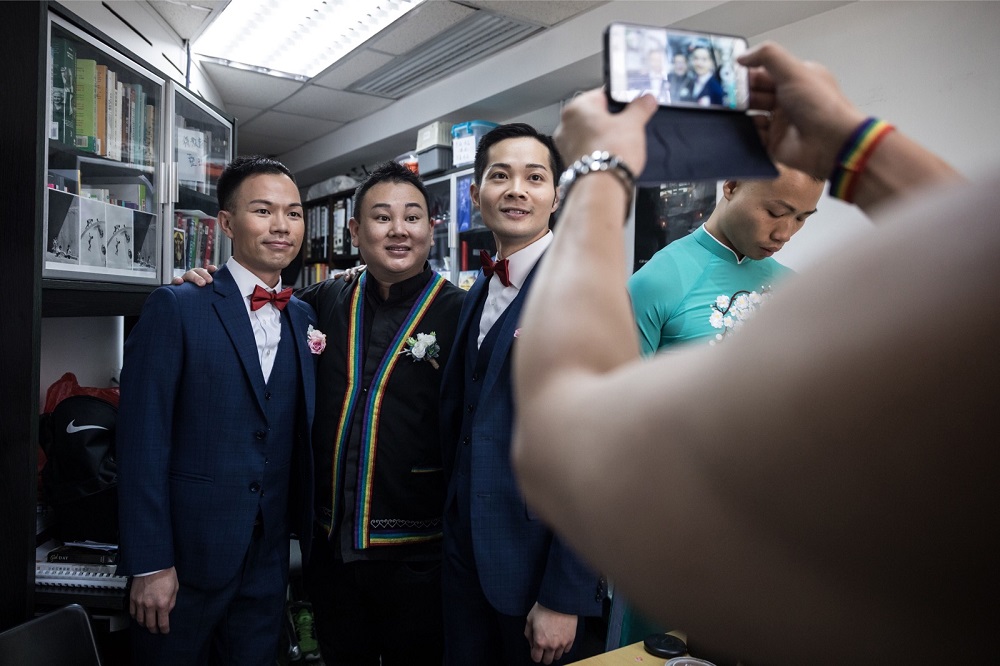 CP So (centre right) and Alvin Chan (left) pose for a photograph with pastor Joe Pang before their wedding ceremony at a church in Hong Kong May 5, 2018. u00e2u20acu201d AFP pic