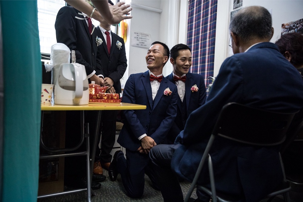 CP So (centre right) and Alvin Chan (centre L) react during a tea ceremony with So’s parents before their wedding ceremony at a church in Hong Kong May 5, 2018. 