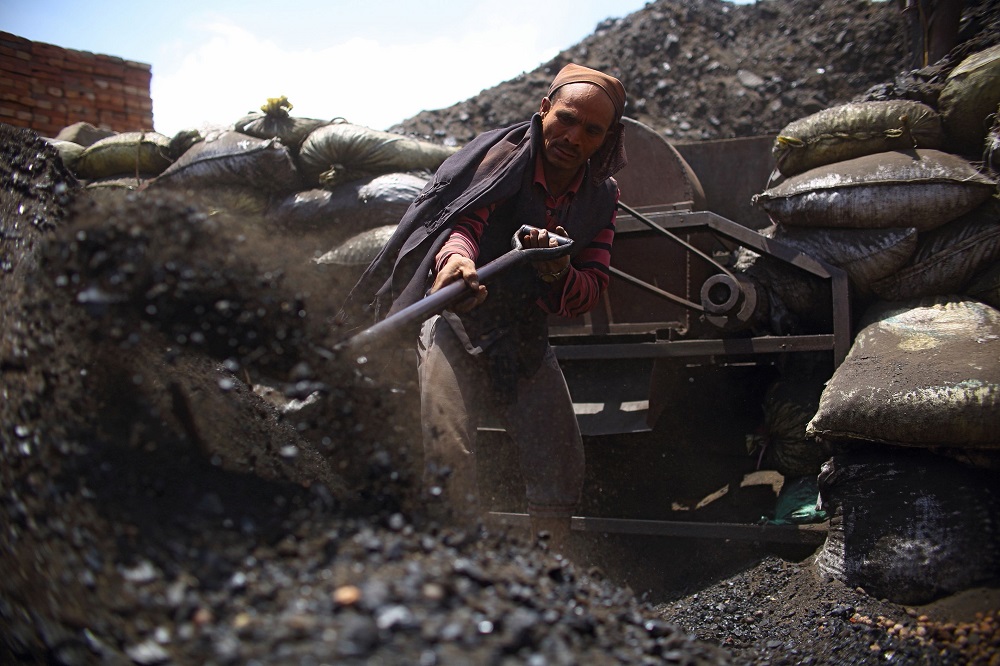 In this photograph taken on May 10, 2018, a Nepali worker shovels coal at a brick factory in Bhaktapur, on the outskirts of Kathmandu. u00e2u20acu201d AFP pic