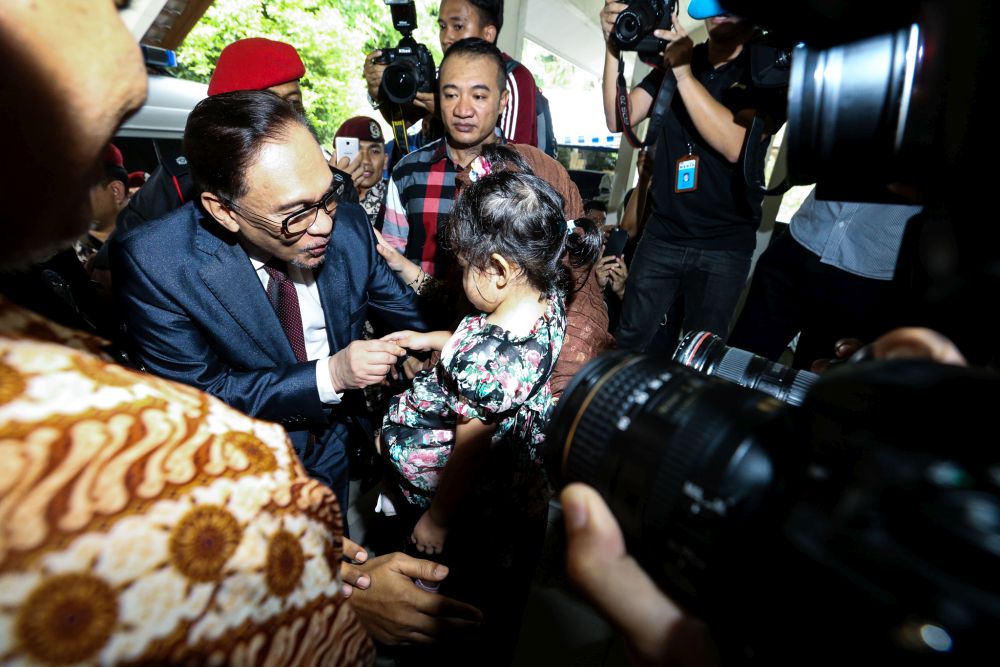 Anwar greets a child as he arrives home in Segambut on May 16, 2018. u00e2u20acu201d Picture by Zuraneeza Zulkifli