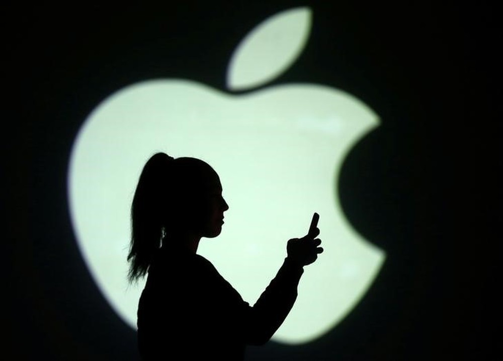 Silhouette of mobile user is seen next to a screen projection of Apple logo in this picture illustration taken March 28, 2018. u00e2u20acu201d Reuters pic 