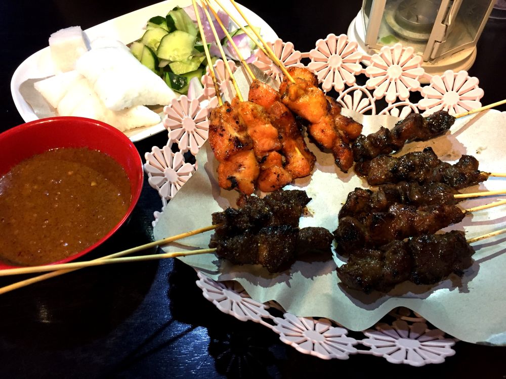 The satay is served with an irresistible bowl of thick peanut sauce, cucumber and onion wedges.